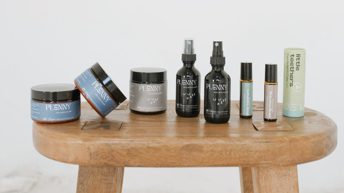 Plenny sleep serums, Dream Creams and rollers lined up on a wooden stool
