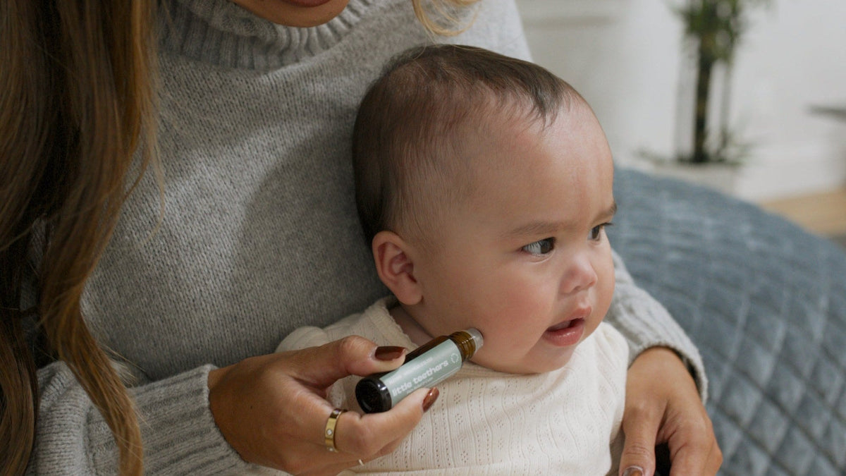 Mom rolling Little Teethers along her baby's jawline
