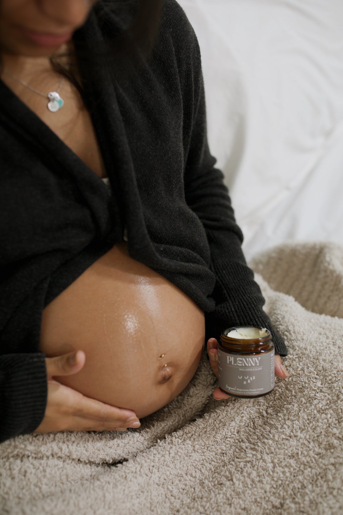 Pregnant mom holding a jar of Original Dream Cream against her belly