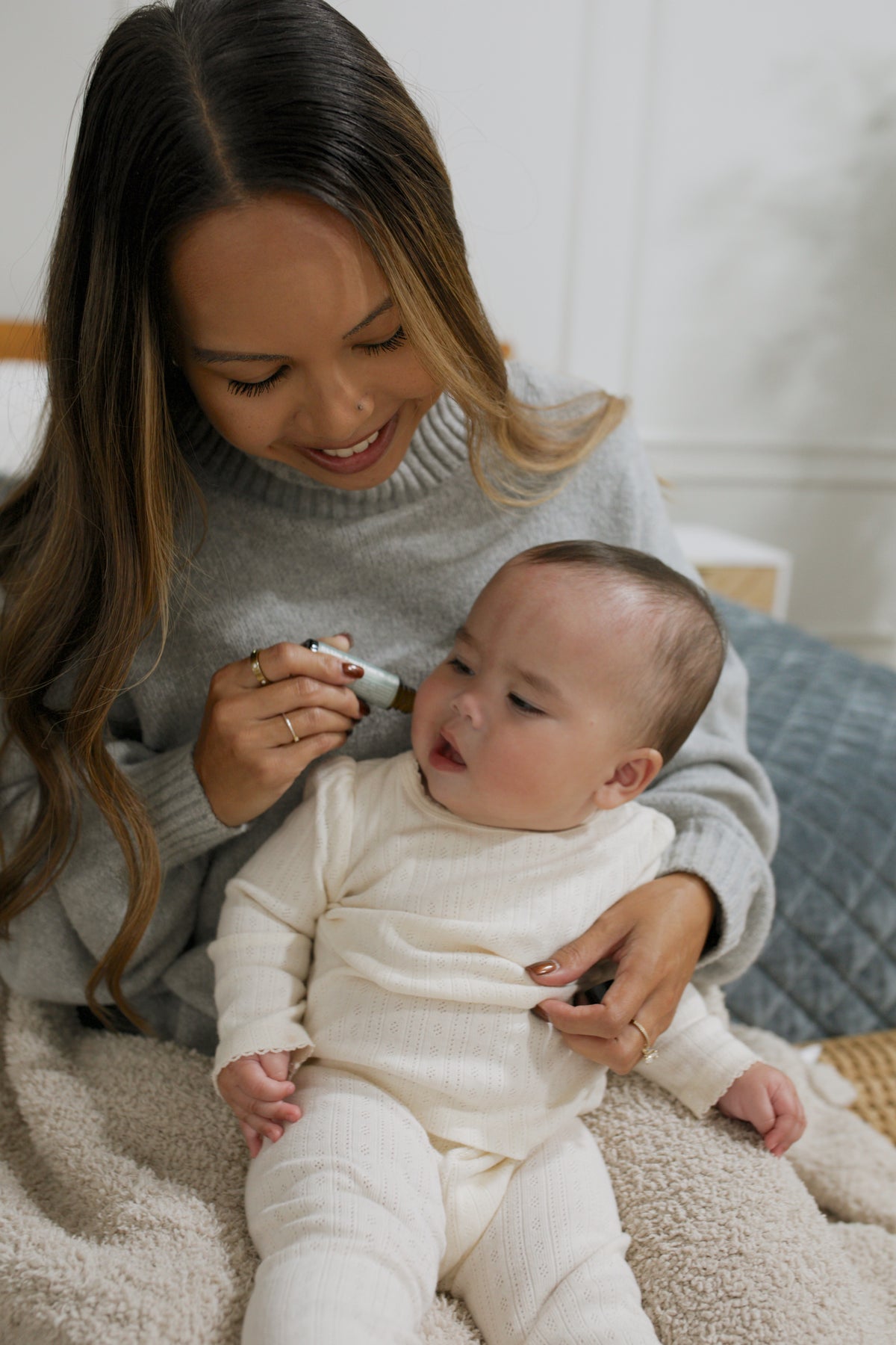 Mom applying Little Teethers roller to her baby's jawline